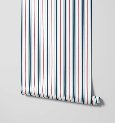 A roll of sailor nautical stripe wallpaper with vertical navy blue red and white stripes for a coastal look