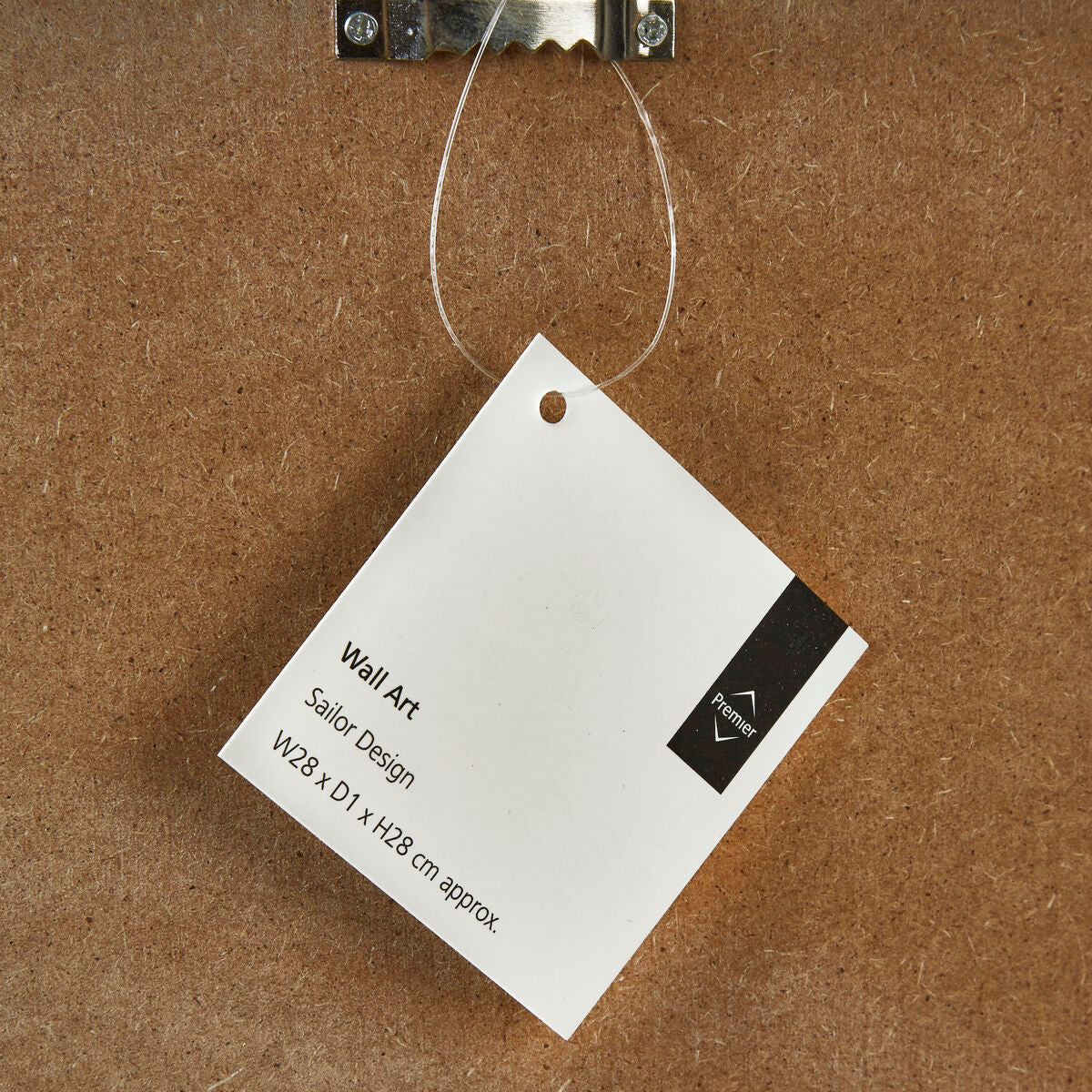 White rectangular tag with black text and logo hanging on brown cardboard backing for sailor wall art blue wall decor