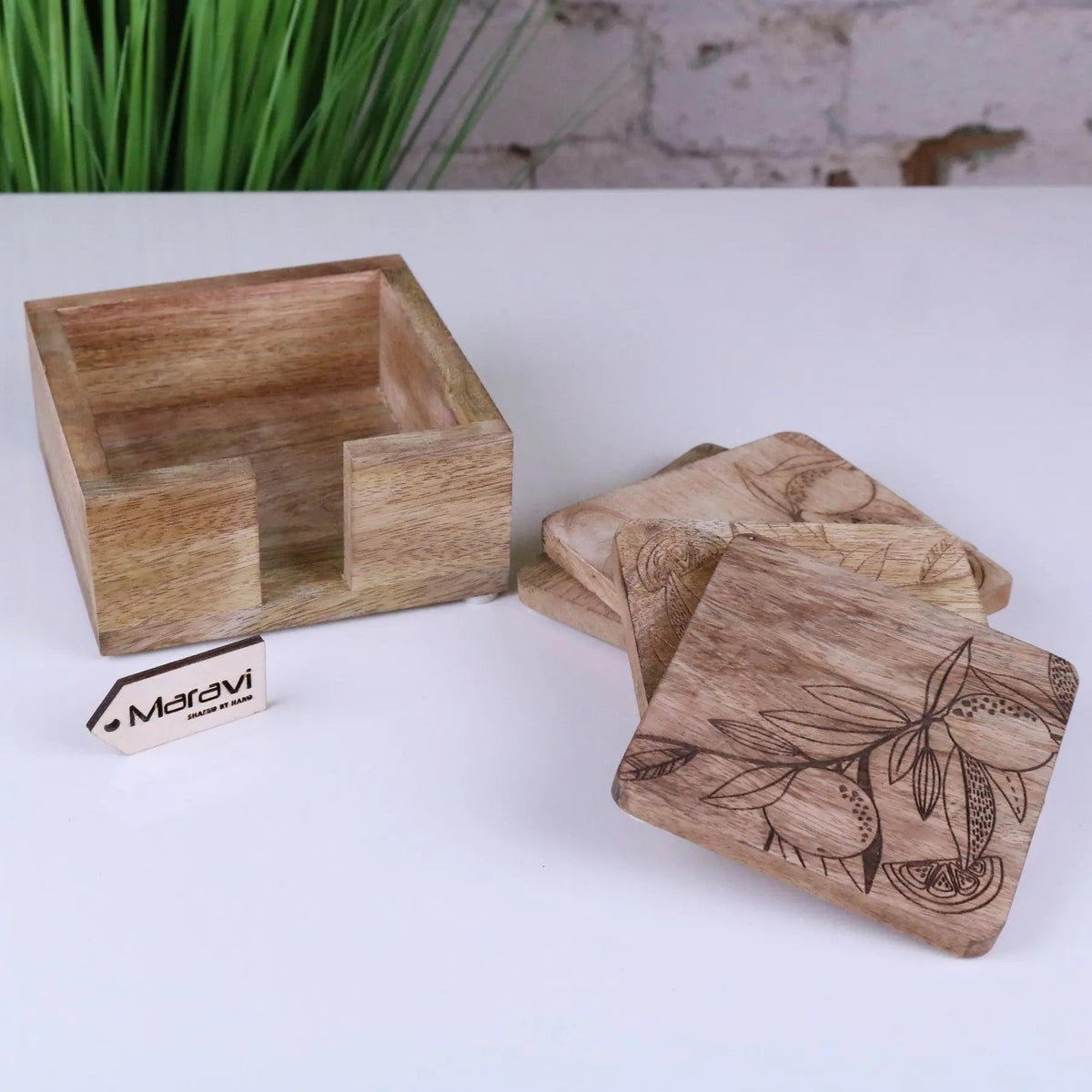 Set of square mango wood coasters with engraved citrus botanical designs and a matching wood storage box