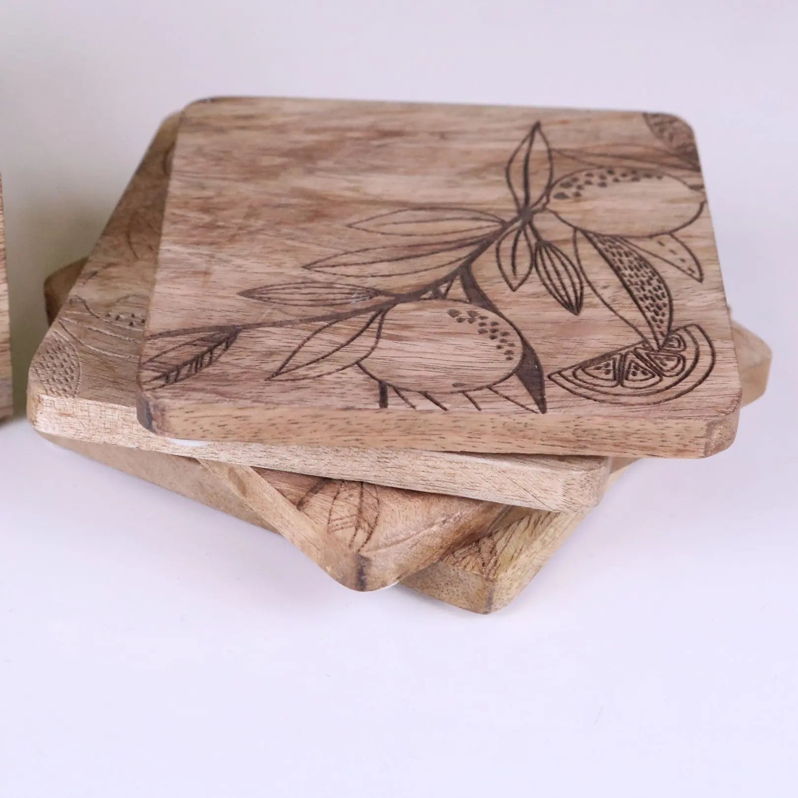 Square mango wood coasters with natural light brown finish engraved with citrus lemon and leaf designs