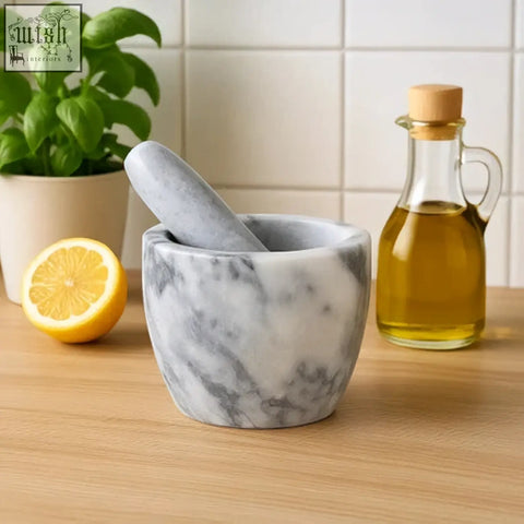 Salerno grey marble tapered mortar and pestle in grey marble with a halved lemon on a wooden countertop