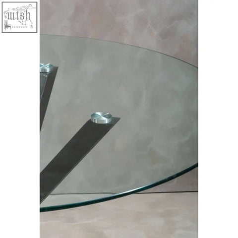 Clear glass salford round dining table with sleek silver supports and black metal legs for modern dining spaces