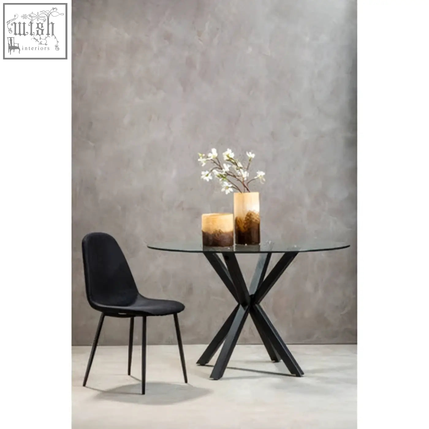 Salford round dining table with black glass top and sleek x-shaped black metal legs perfect for modern spaces
