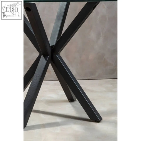 Black metal x shaped legs of the salford round dining table with sleek industrial design and sturdy build
