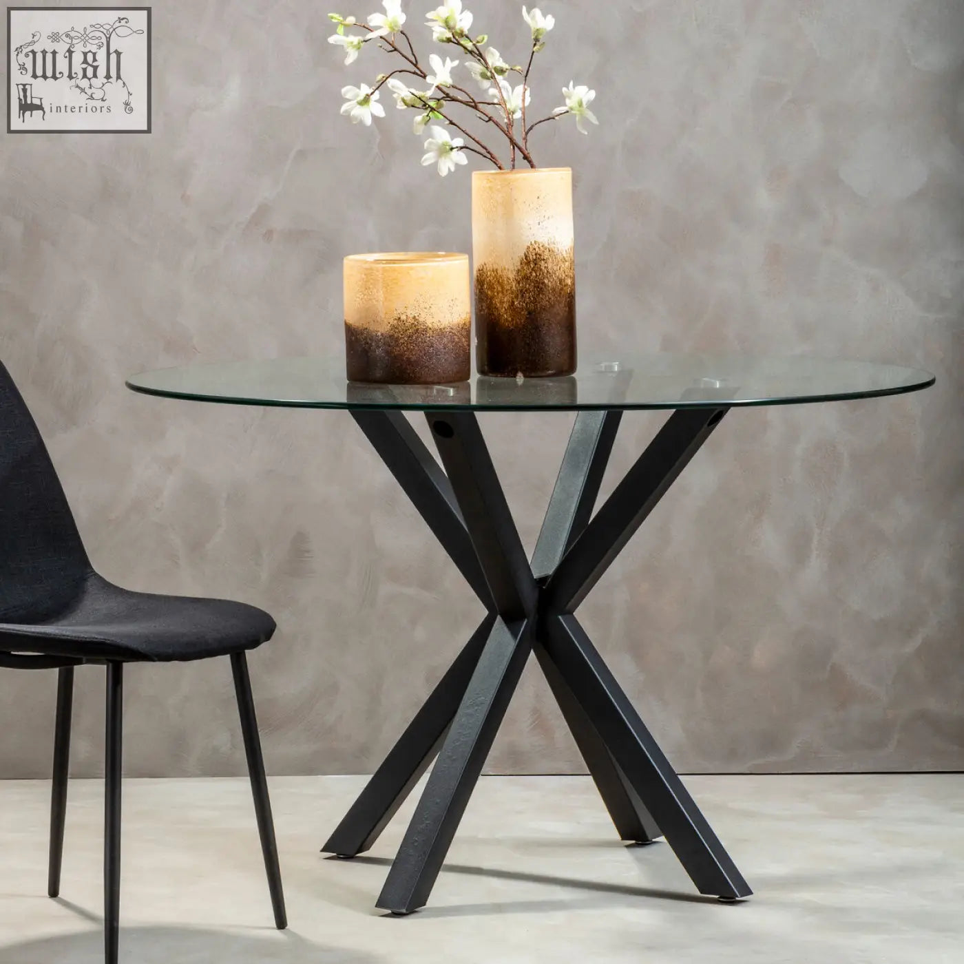 Salford round dining table with black metal x-shaped legs and clear glass top for modern round dining table setup