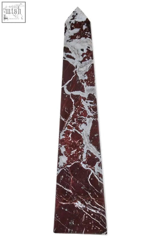 A tall slender salmo large red marble obelisk with polished red and white marble and a pointed top