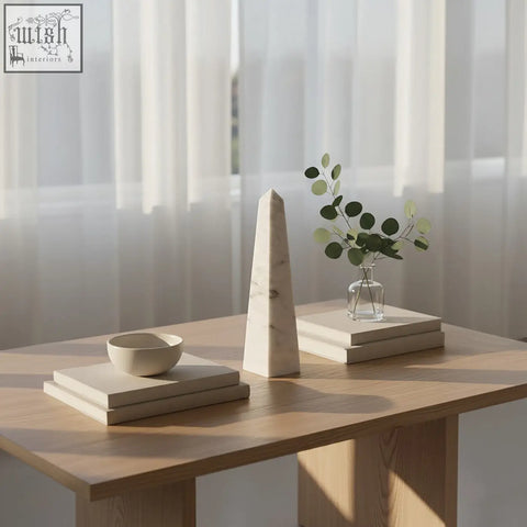 A sleek salmo large white marble obelisk with subtle gray veining on a wooden table