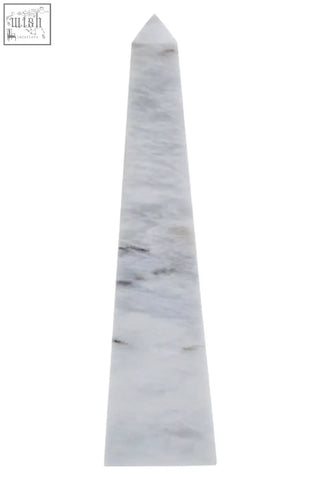 A sleek salmo large white marble obelisk with subtle gray veining and a pointed top perfect for decor