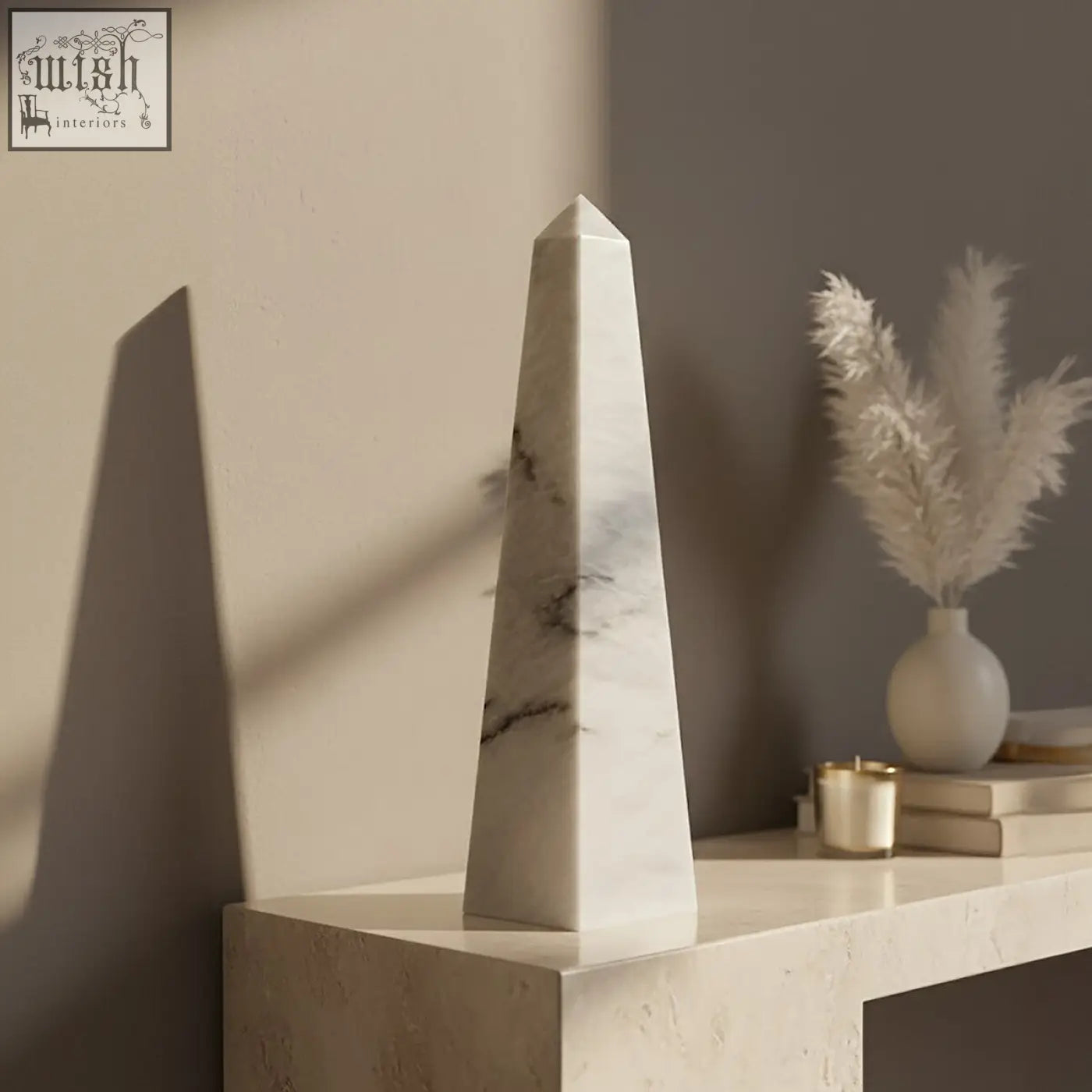 A sleek salmo large white marble obelisk with subtle gray veining on a minimalist console table