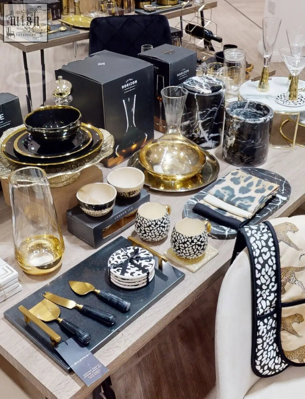 Salmo oval black marble chopping board with black and gold ceramic dinnerware and leopard print accents