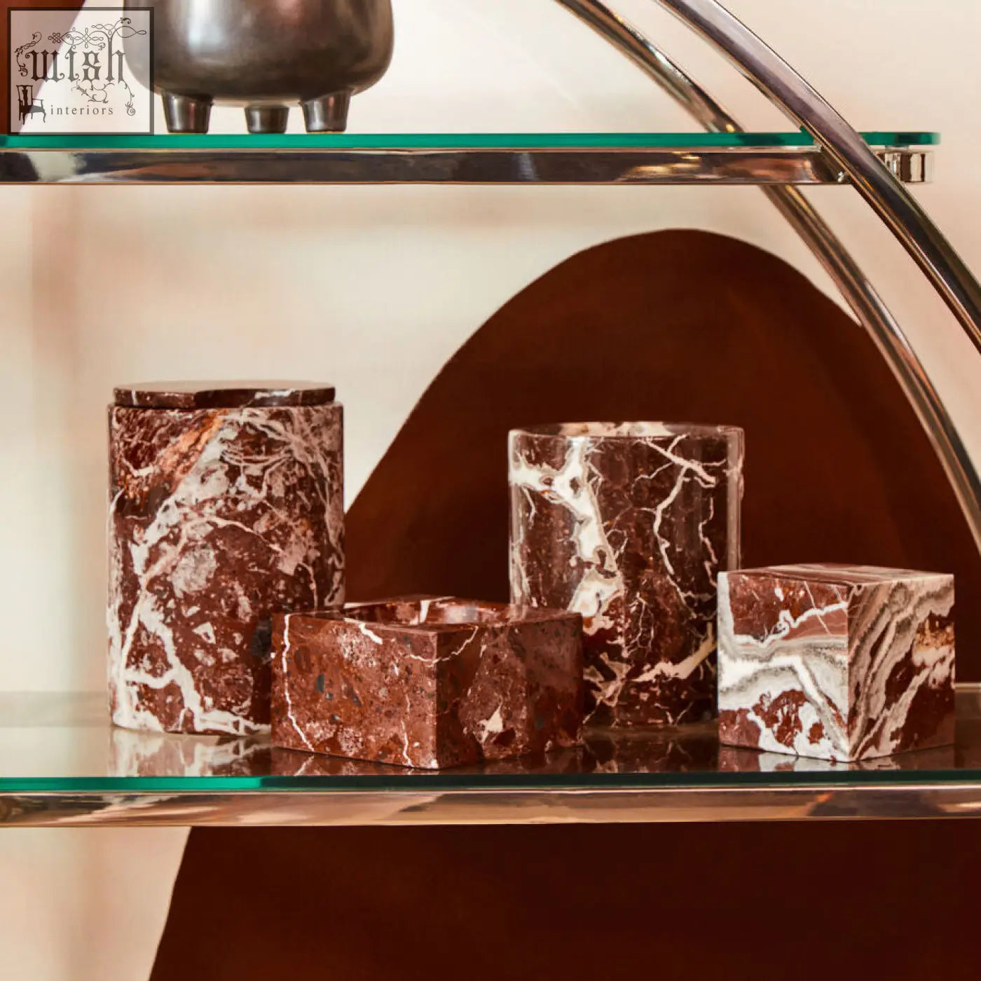 Brown and white marble candle holders in geometric shapes complement the salmo red marble wine cooler design