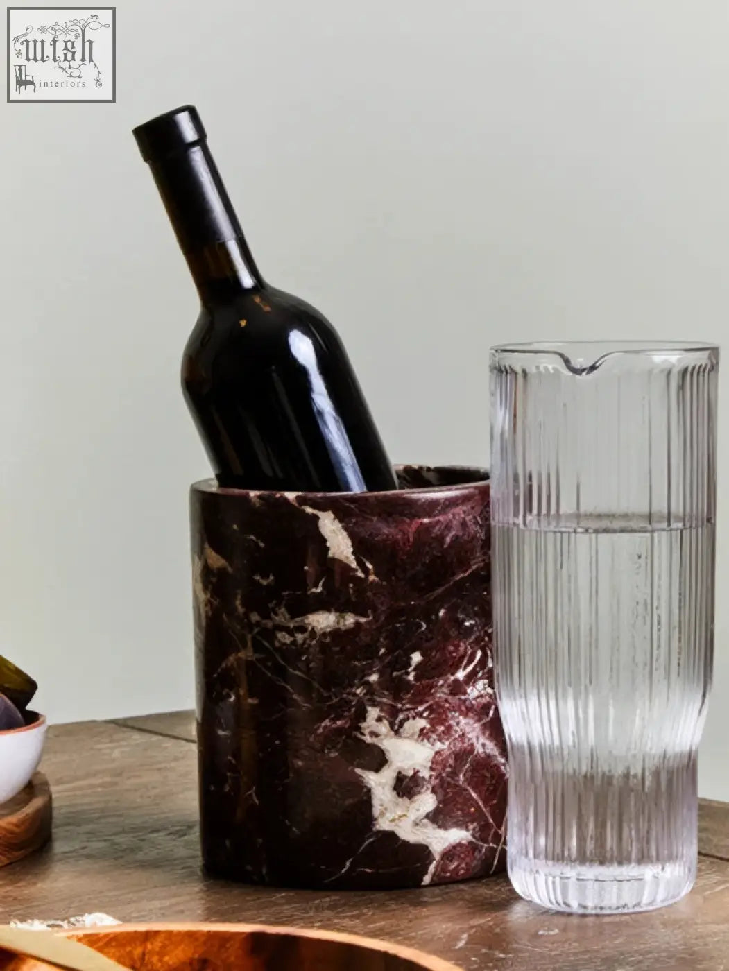 Salmo red marble wine cooler made of dark burgundy marble with white veining holding a black wine bottle