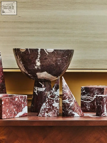 A dark brown and white veined marble bowl with a sleek modern design from the salmo set of two red marble bookends