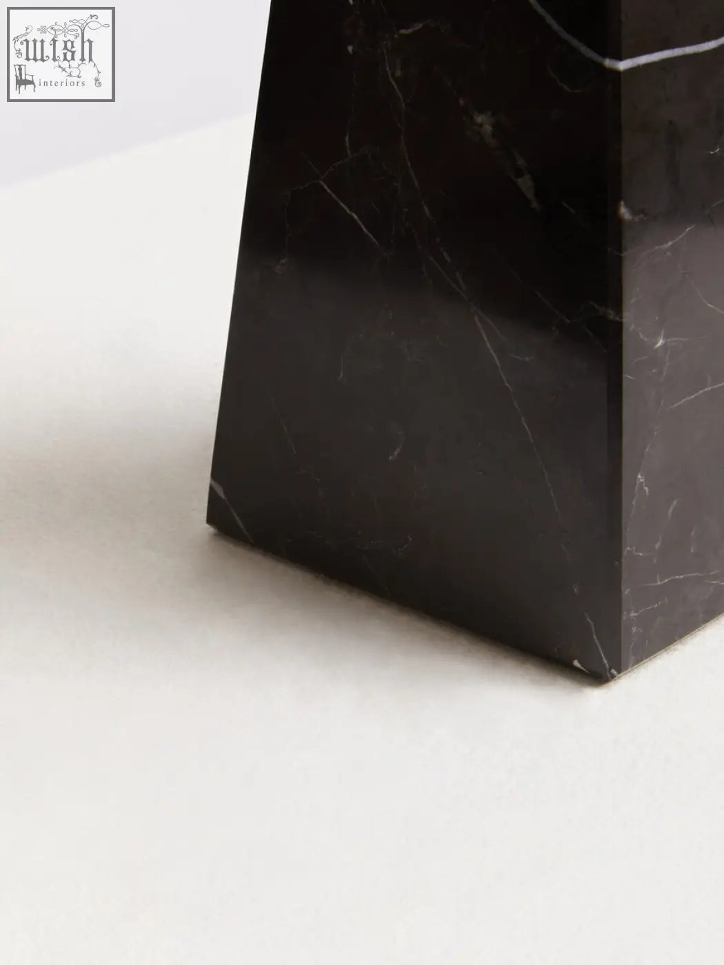 Salmo small black marble obelisk with sleek polished surfaces and subtle white veining on a small black marble pedestal