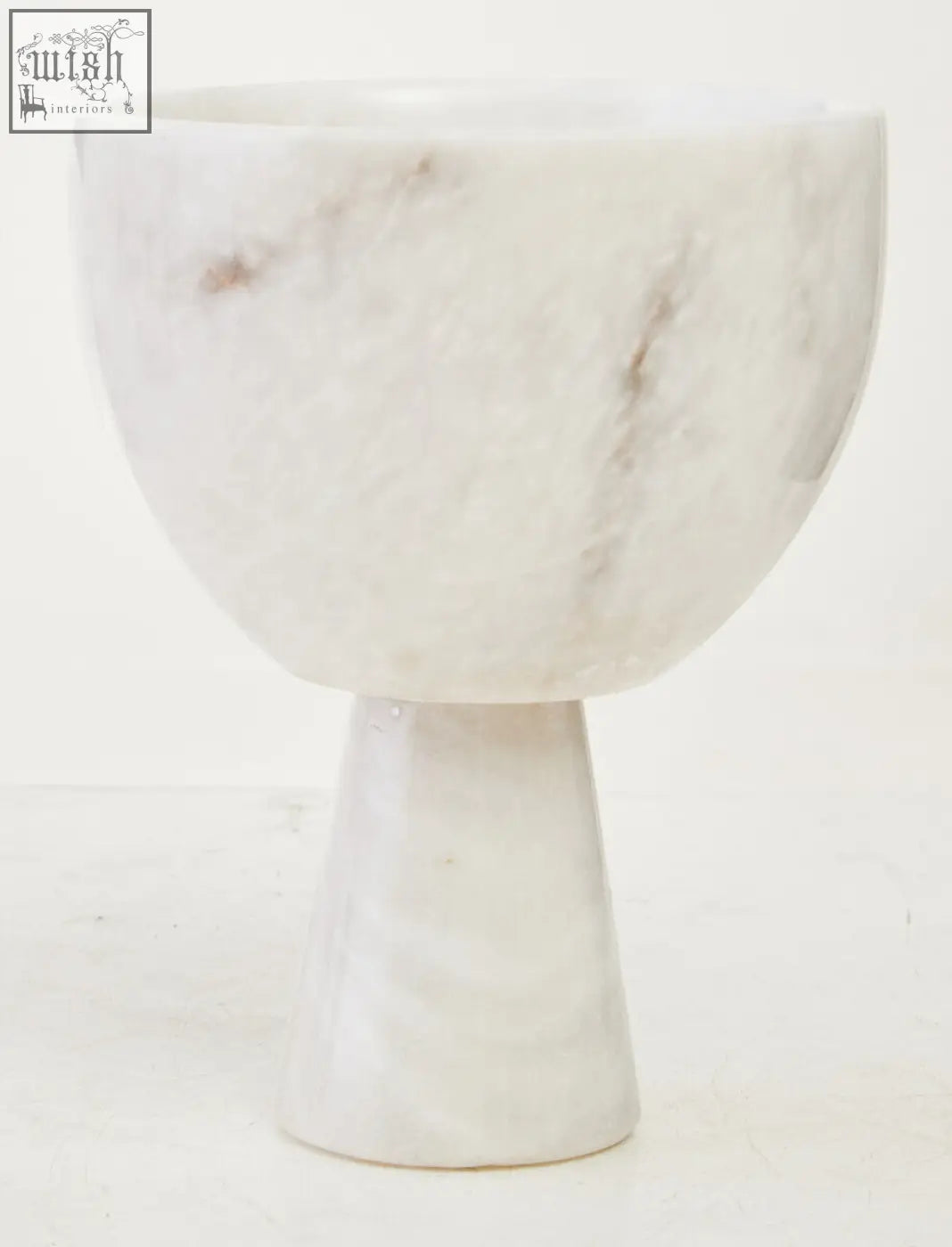 A salmo small white marble pedestal bowl with subtle gray veining and a smooth rounded rim