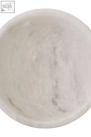 A smooth off-white salmo small white marble pedestal bowl with a slightly textured interior surface