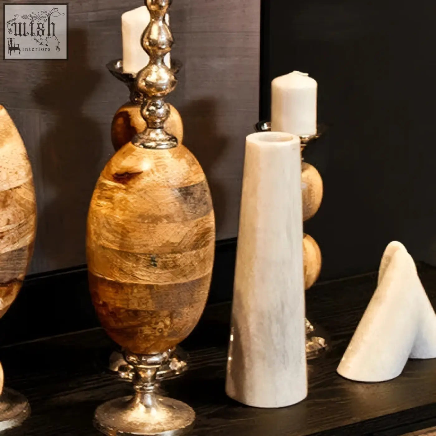 A polished salmo white marble tapered vase with natural wood grain and a metallic silver base and ornate top