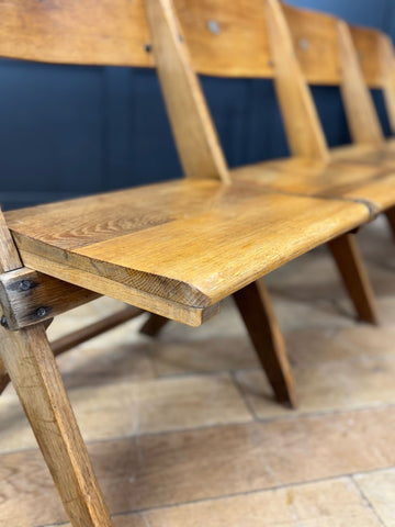 Light-colored oak church chairs bench seat with visible grain and simple sturdy design perfect for hallway seating