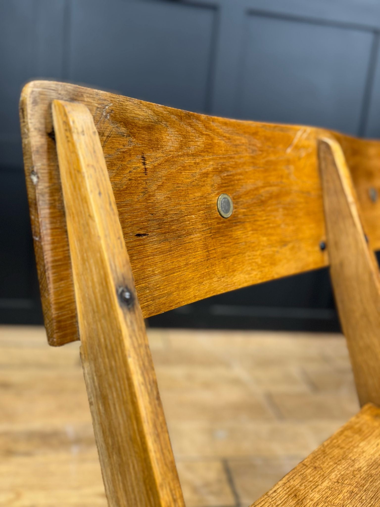 A rustic oak church chair with a warm natural finish and visible grain perfect for hallway folding seating