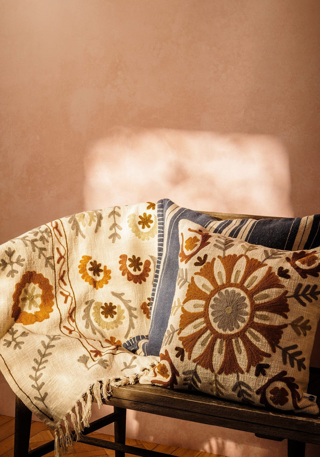 Cream-colored embroidered throw blanket with floral brown orange gray patterns and fringed edge for samuel suzani cushion brown