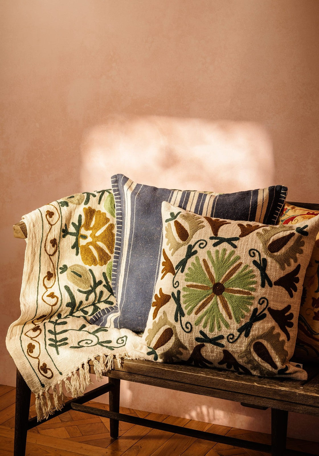 Beige embroidered samuel suzani cushion with intricate green brown and black floral patterns for cozy decor