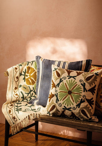 Beige embroidered samuel suzani cushion with intricate green brown and black floral patterns for cozy decor