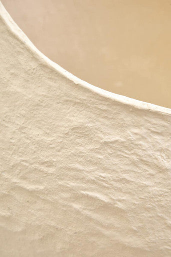 A smooth curved shoreline inspires the beige color of the sanai cotton mache large beige planter perfect for decor