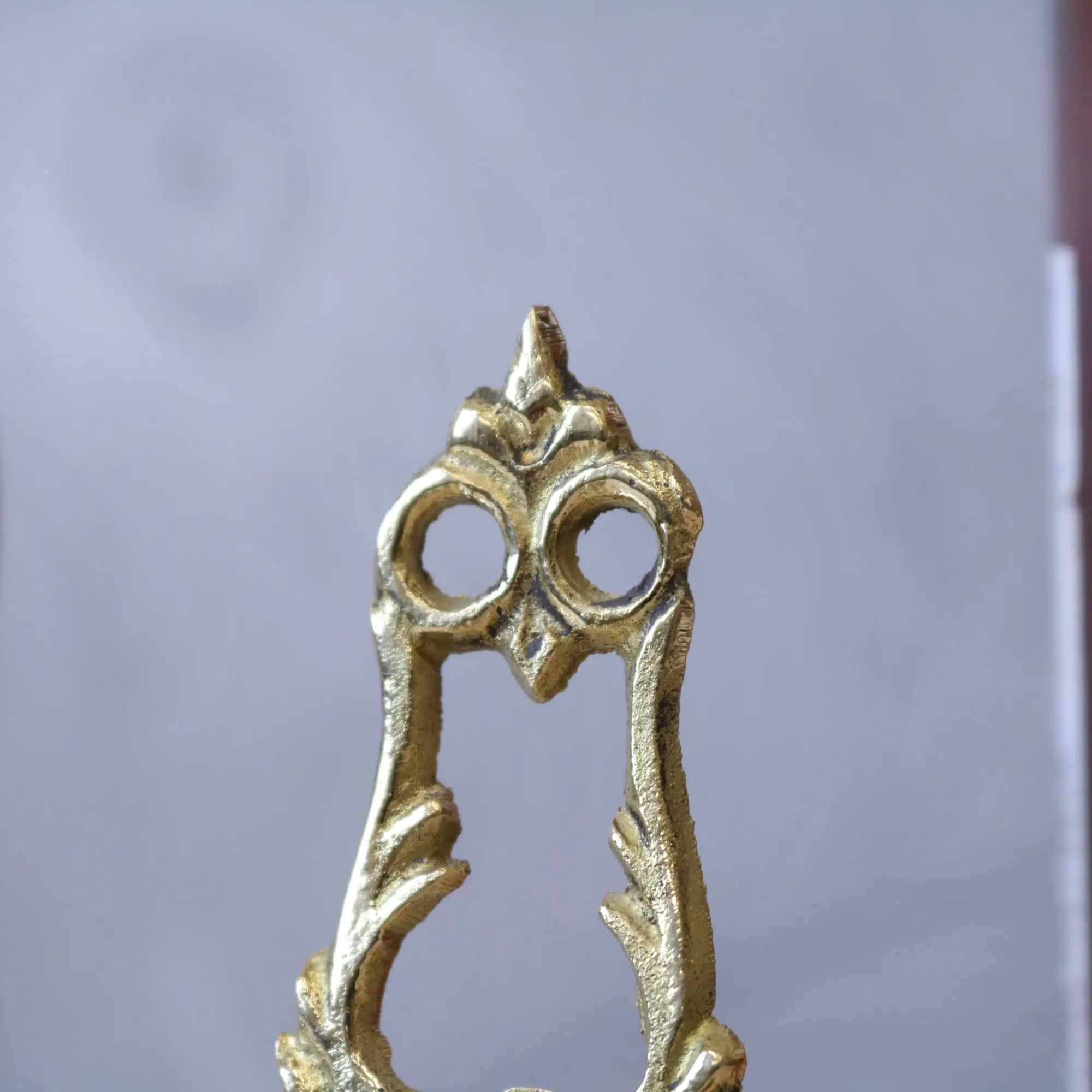 Golden owl-shaped brass door handle with ornate vintage design featured alongside saramati mini easel stands