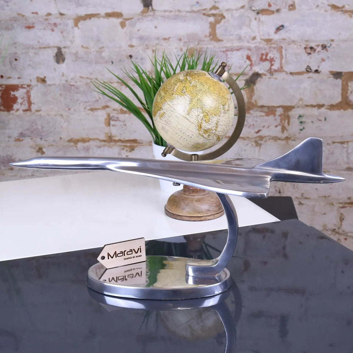 Shiny silver saran concorde model airplane on sleek metallic stand perfect for display and decor