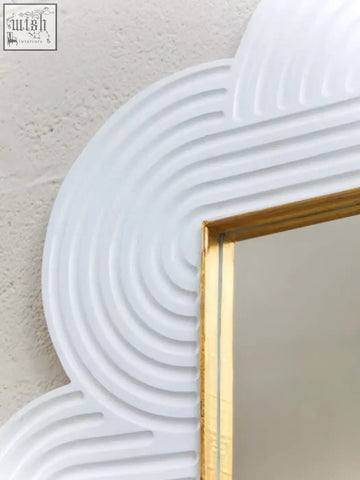 White cloud-shaped wall mirror with gold-trimmed frame and ridged detailing in mango wood finish