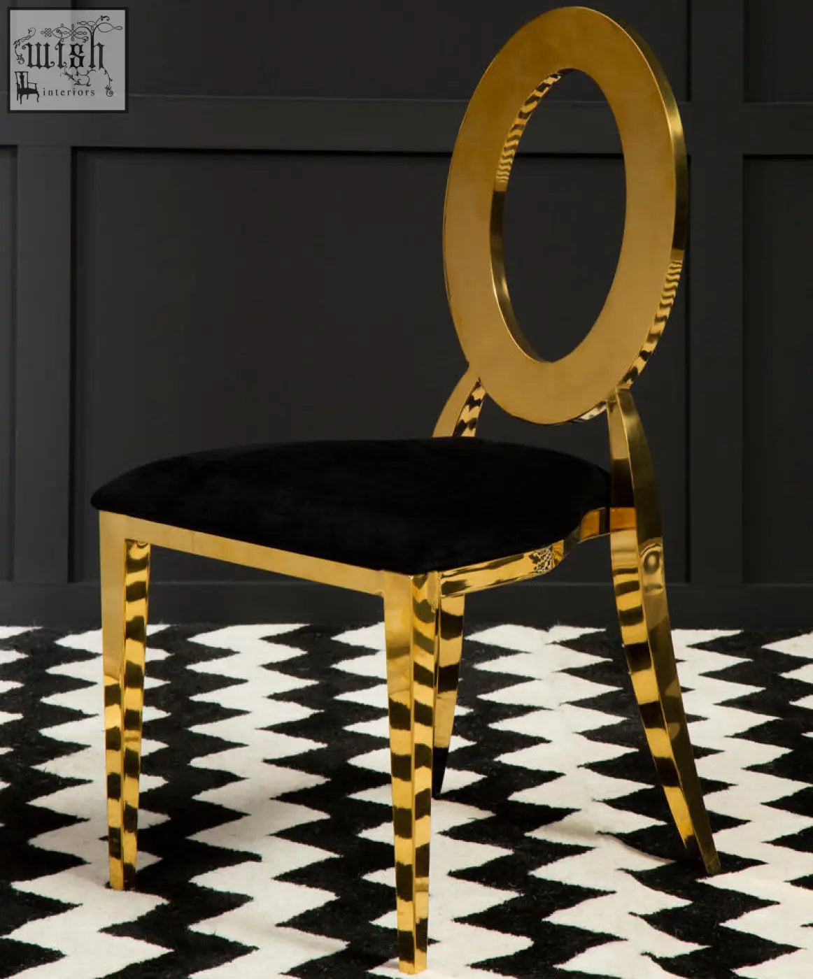 A sarita stackable gold chair with a sleek gold frame, black velvet seat, striped legs, and an oval backrest