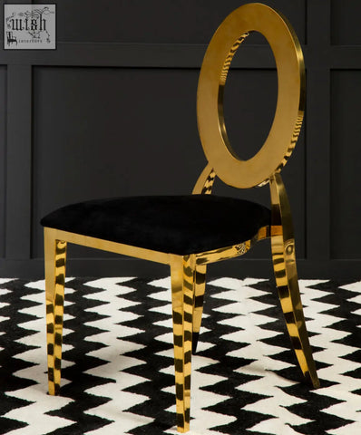 A sarita stackable gold chair with a sleek gold frame, black velvet seat, striped legs, and an oval backrest