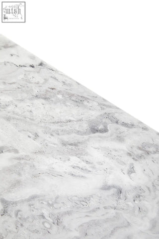 A saronno grey marble side table with a sleek white marble surface featuring subtle grey veining and stainless steel legs