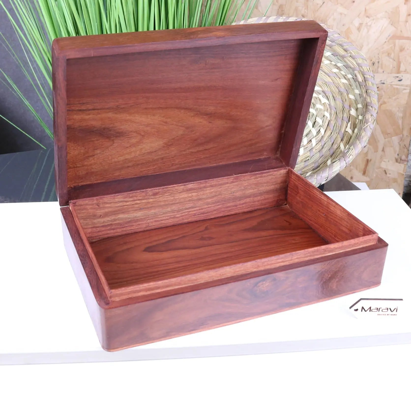 A polished sateek large hand carved wooden box with rich mahogany finish and visible grain patterns