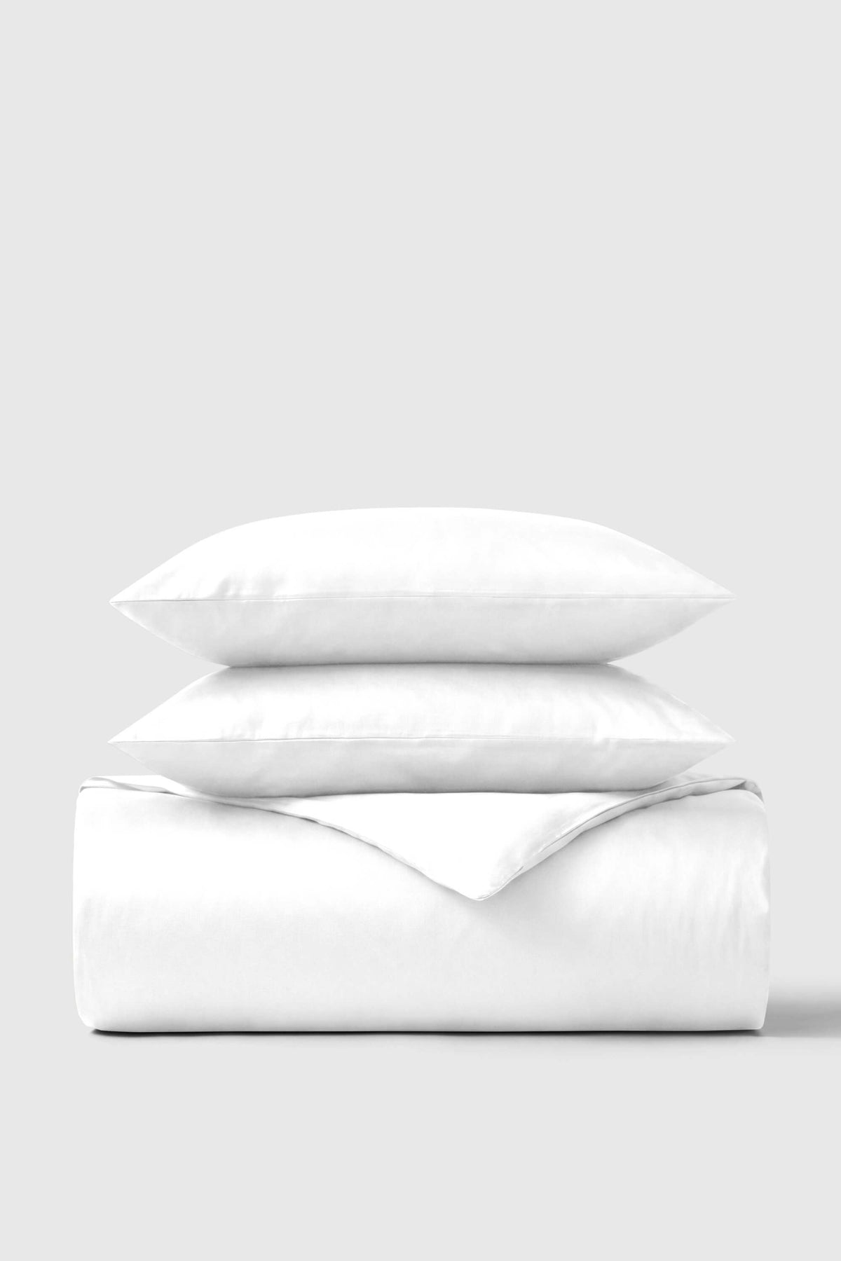 White cotton sateen duvet cover set with matching pillows neatly folded perfect for cozy bedding use