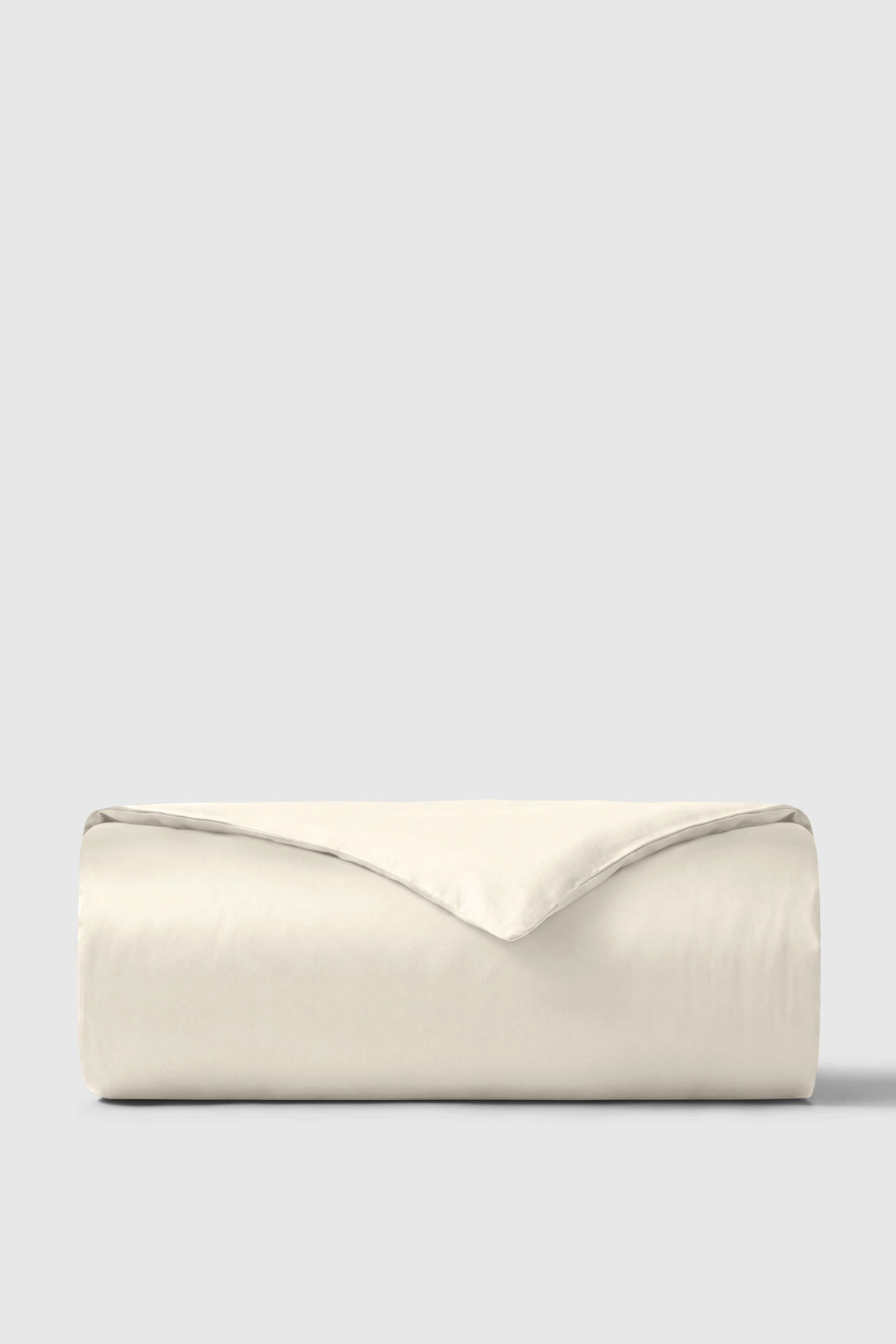 Cream-colored sateen duvet cover neatly folded showing smooth luxurious texture on satin duvet cover