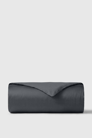 Dark gray sateen duvet cover neatly rolled against a neutral background perfect for stylish bedroom decor