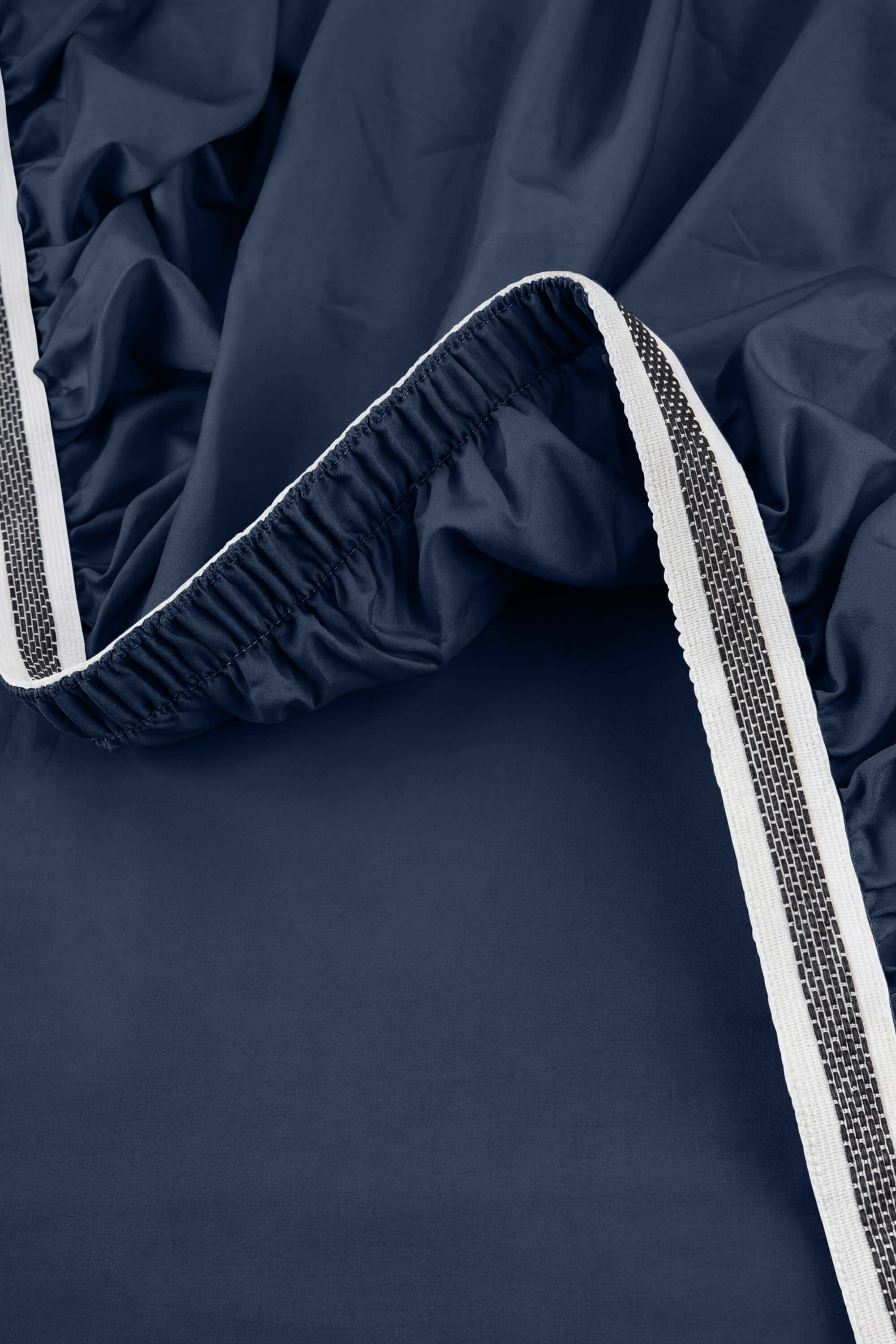 Navy blue satin sheet with black and white striped elastic edge from sateen essentials bedding set
