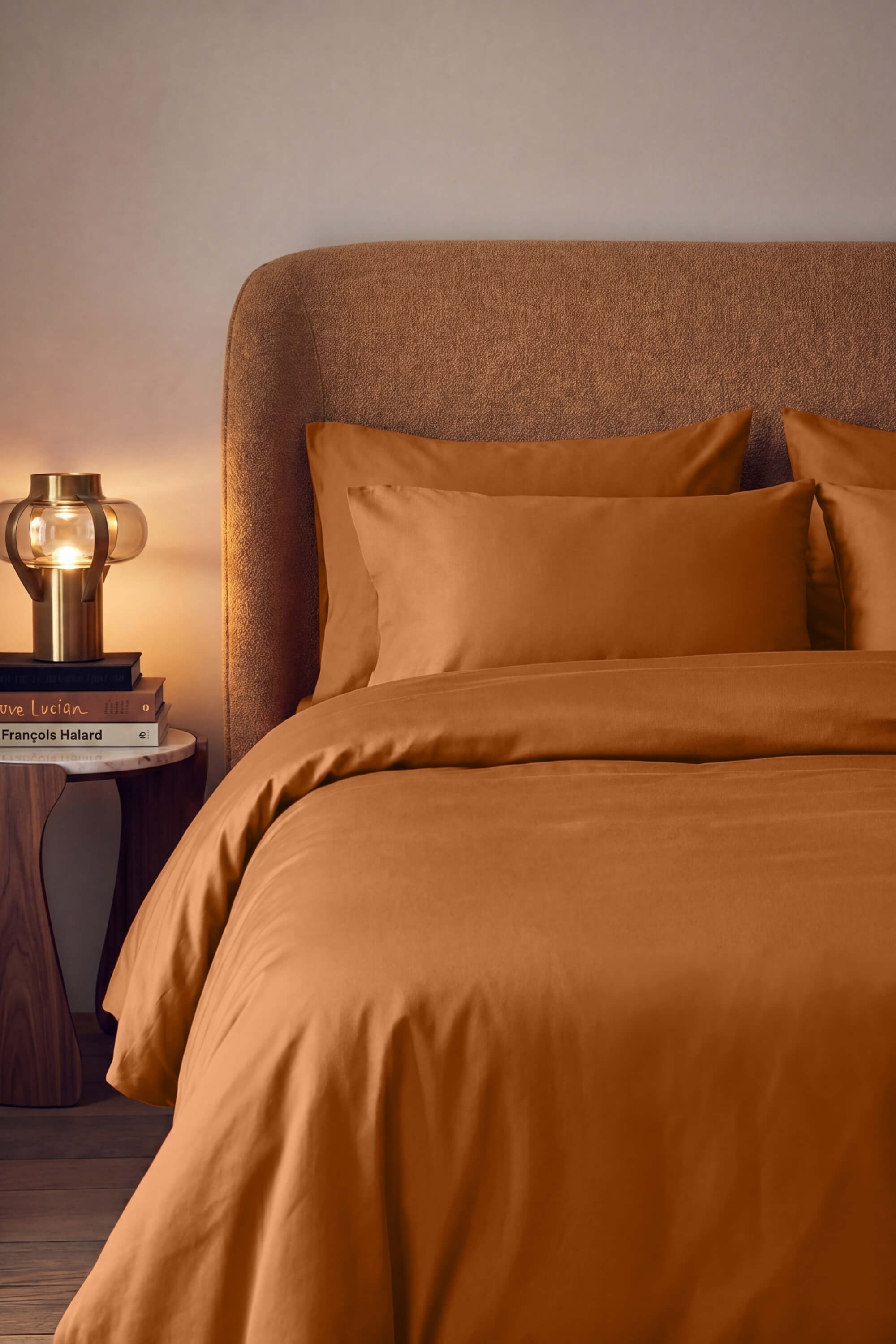 Warm amber satin duvet cover set with matching pillows and textured headboard from sateen essentials bedding
