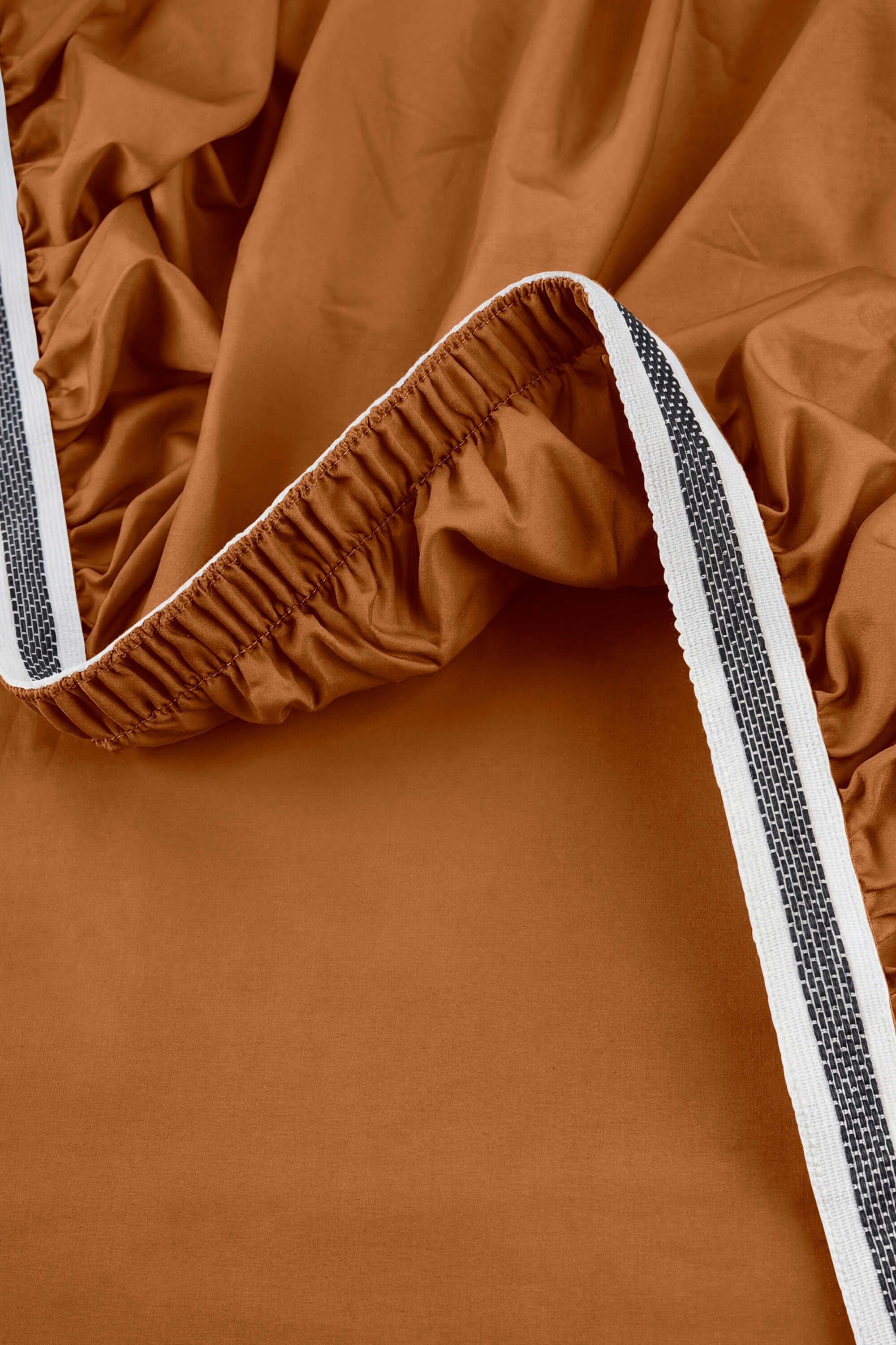 Warm terracotta sateen essentials bedding set with ribbed elastic edge and white gray striped trim