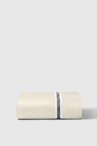 Cream-colored sateen fitted sheet with subtle black and white striped band across center in soft satin material