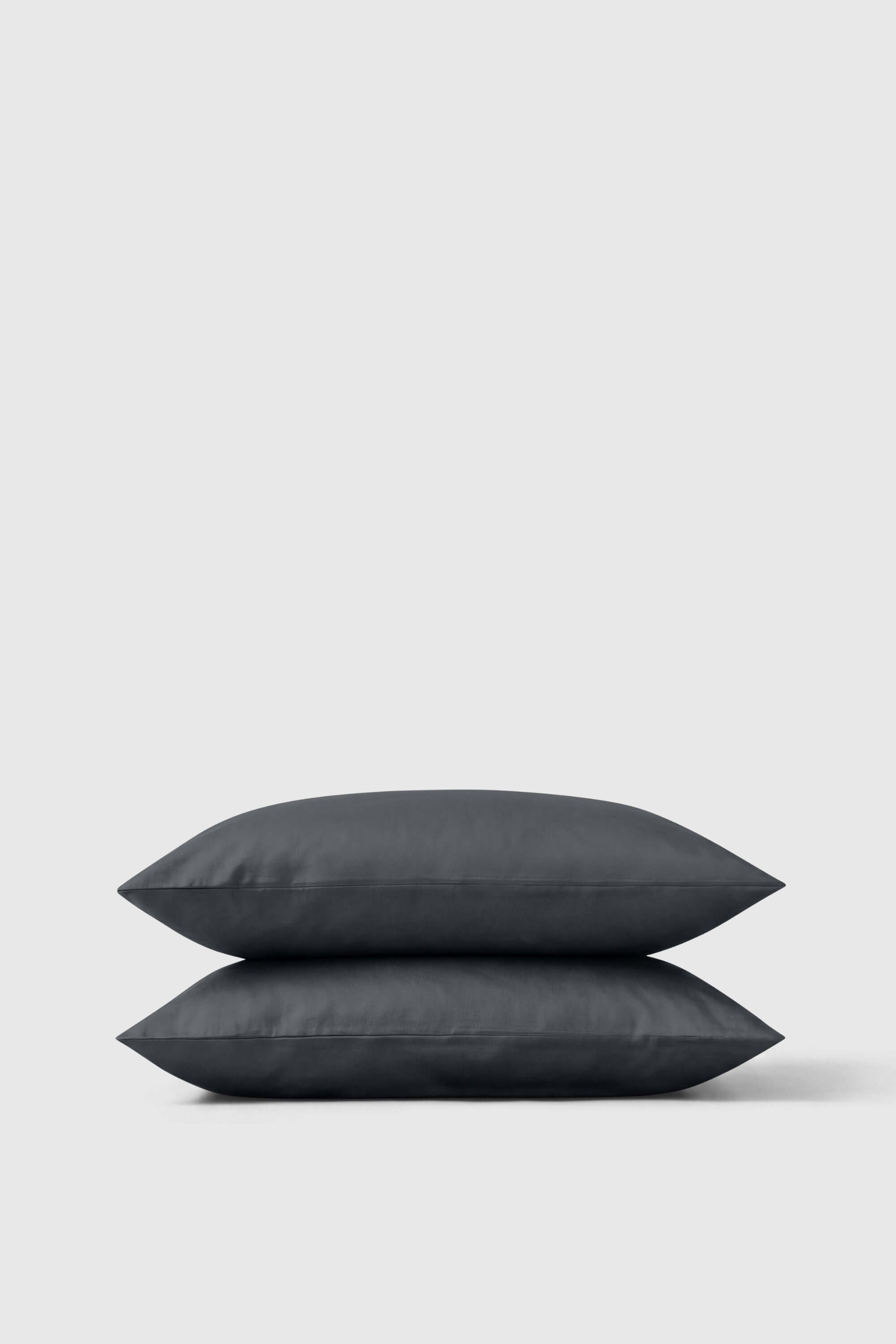 Two dark gray softly textured sateen pillowcases stacked neatly in a sateen pillowcase pair