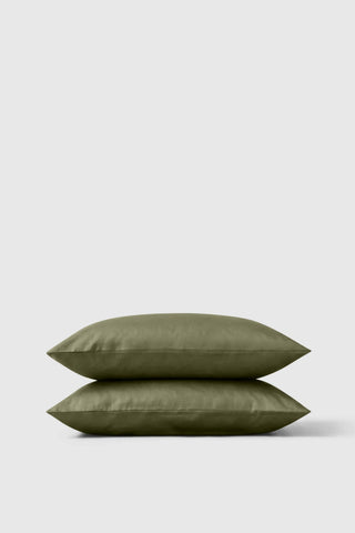 Olive green sateen pillowcase pair neatly stacked showing smooth satin finish for luxury sleep comfort
