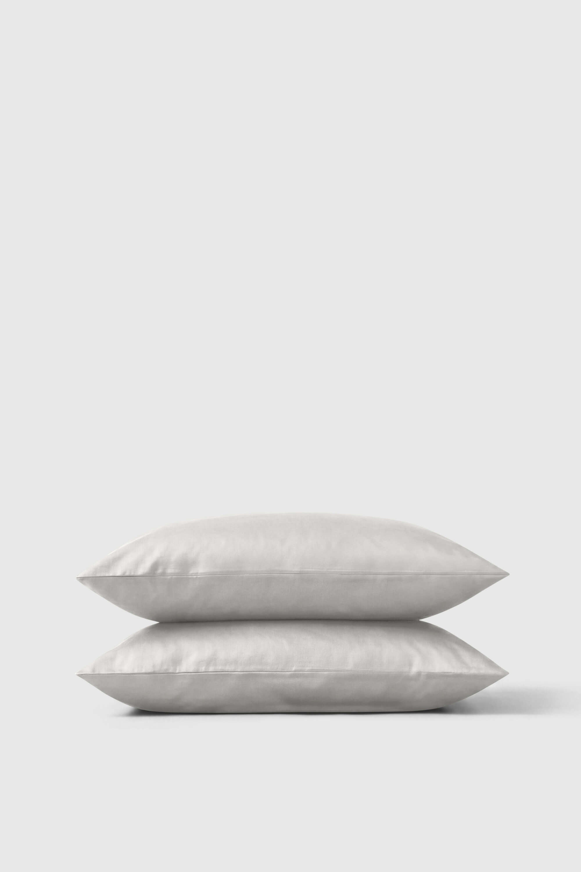 Two off-white satin pillowcases with a smooth glossy finish in a sateen pillowcase pair perfect for cozy beds