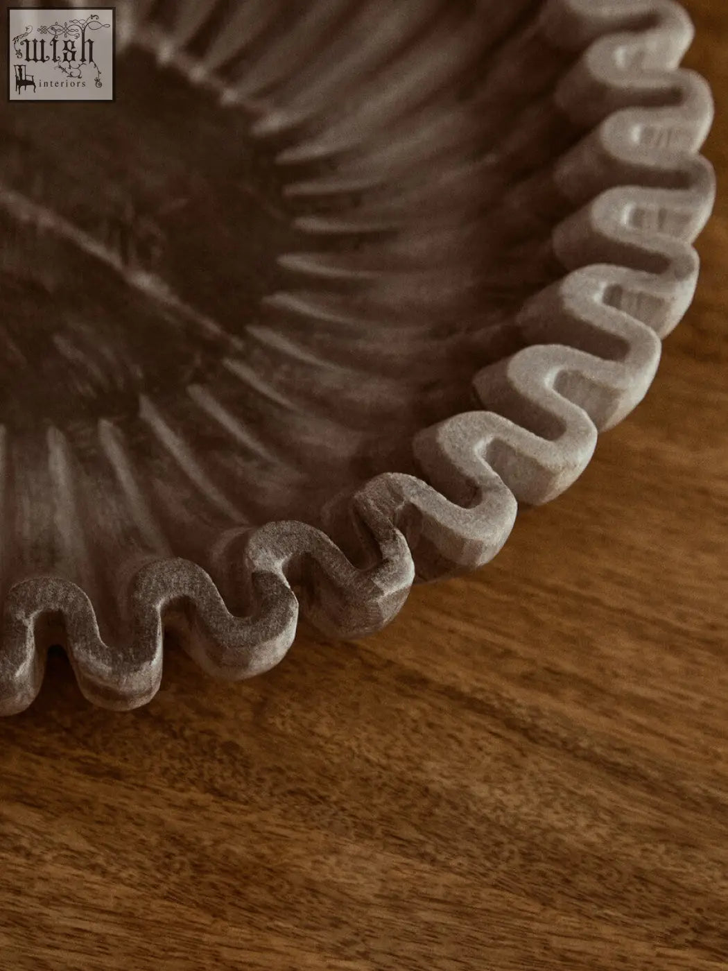 A rustic dark gray ceramic fluted marble bowl with scalloped edge perfect for compact surfaces