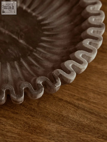 A rustic dark gray ceramic fluted marble bowl with scalloped edge perfect for compact surfaces