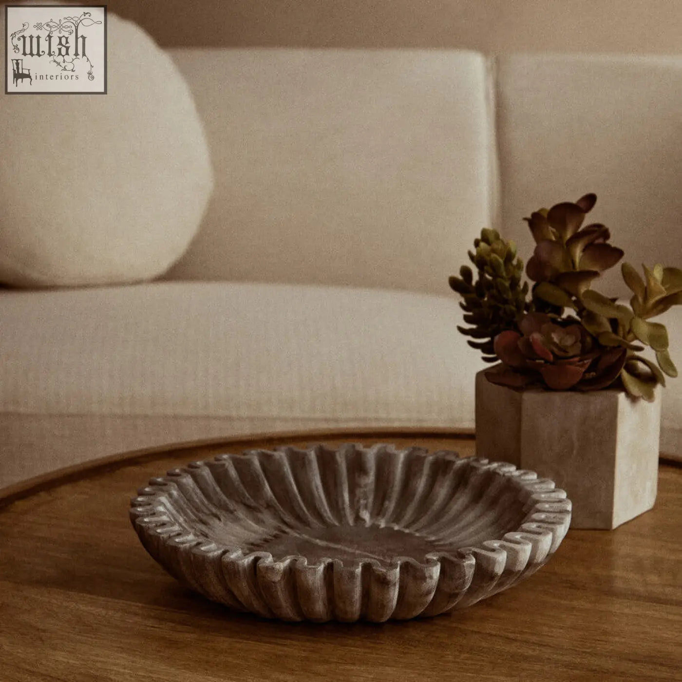 A rustic gray fluted marble bowl with a petal-like rim perfect for compact surfaces on a wooden table
