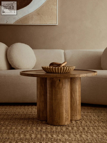 Rustic wooden coffee table with round top and four legs holding a large ochre marble bowl for stylish decor