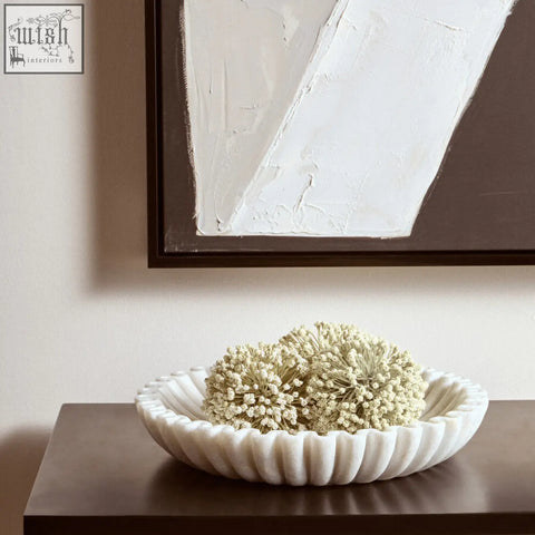 White marble bowl with fluted edges holding dried white flowers in the savio large white fluted marble bowl
