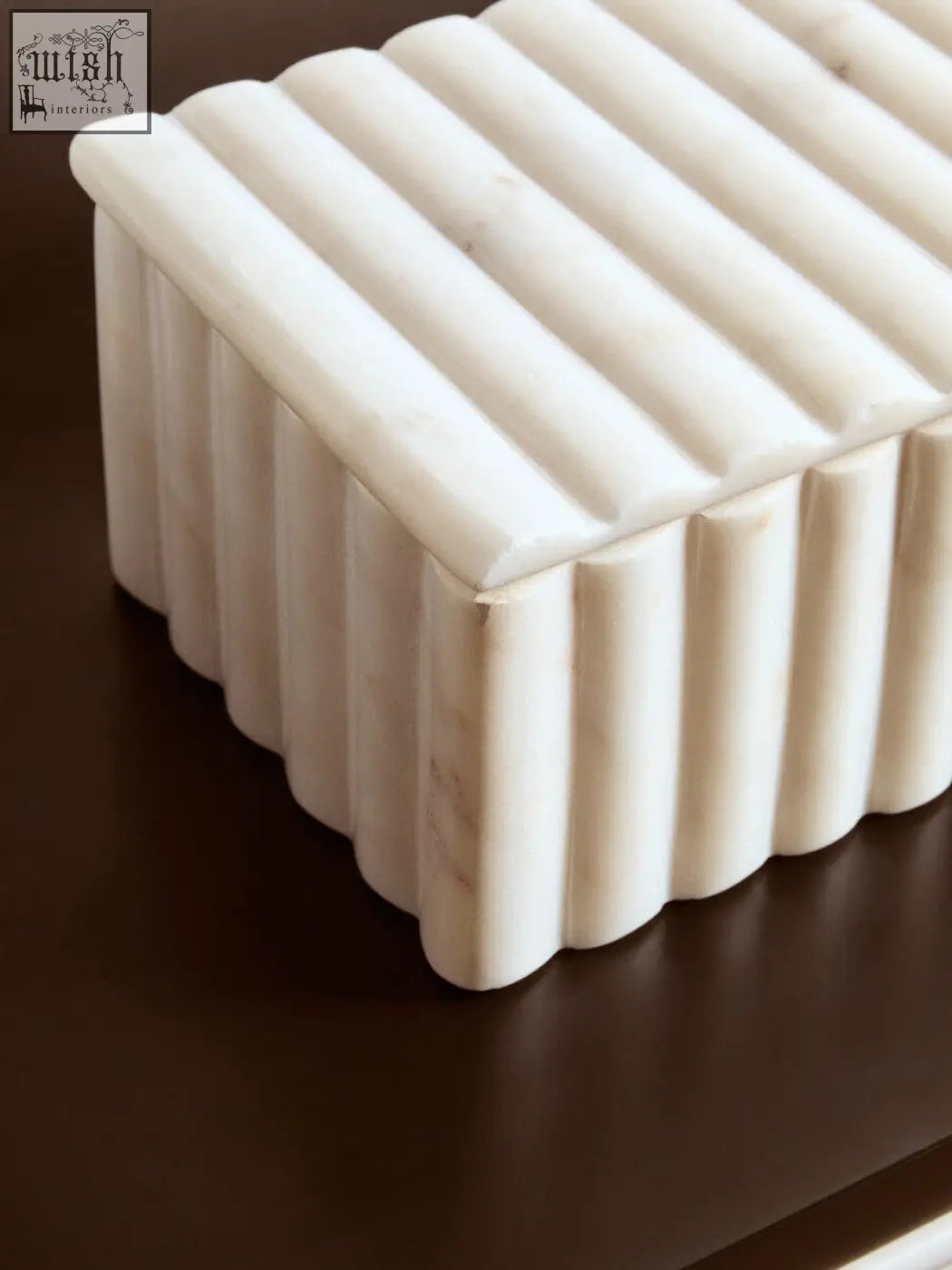 A sleek off-white white marble box with vertical ribbed grooves and subtle grey veining for stylish storage